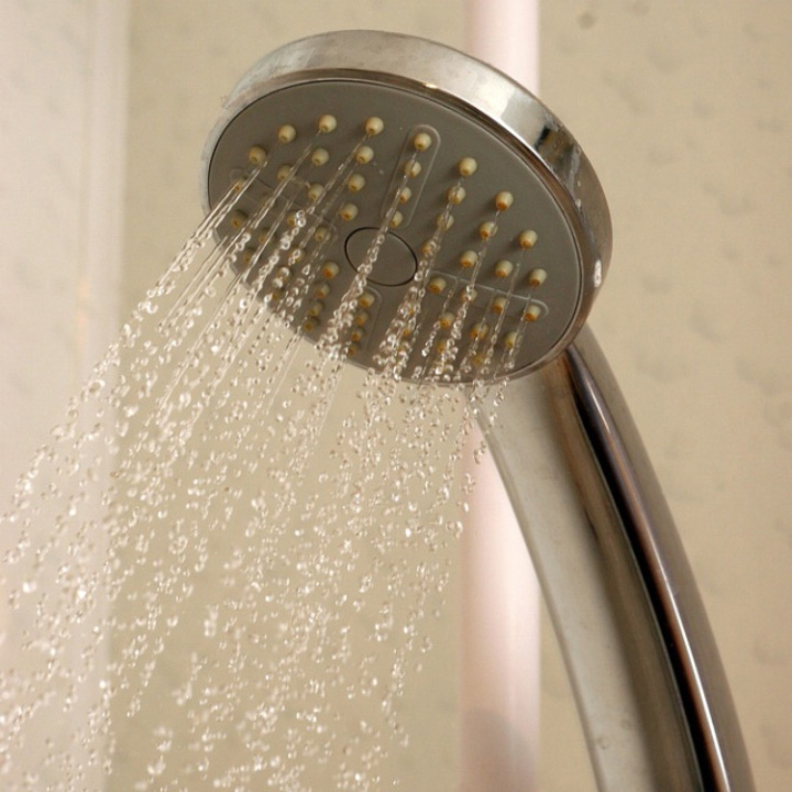 Un primer plano a un grifo de ducha emitiendo agua